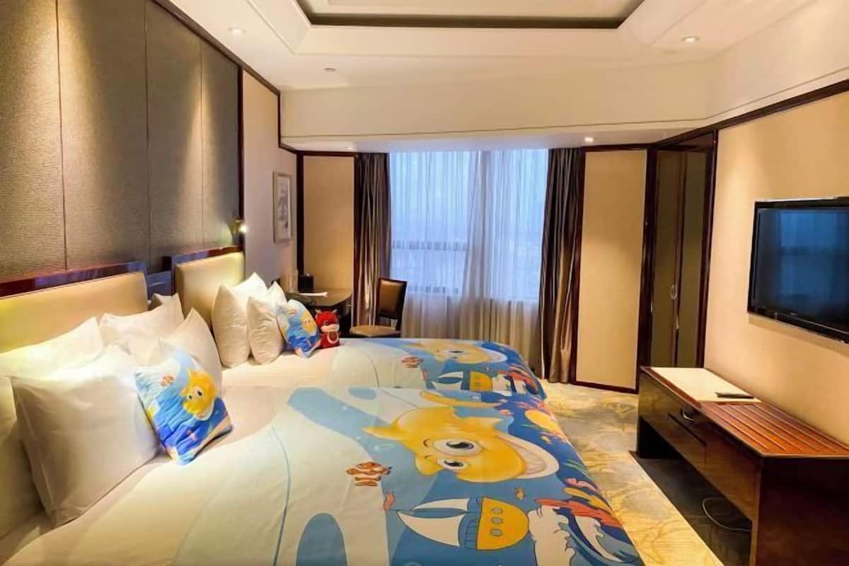 Une chambre d’hôtel avec un grand lit, une télévision et un bureau.