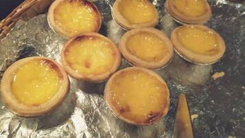 A tray of custard tarts on foil.