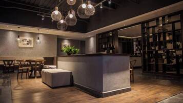 Un interior moderno con una barra central, suelo de madera e iluminación colgante.