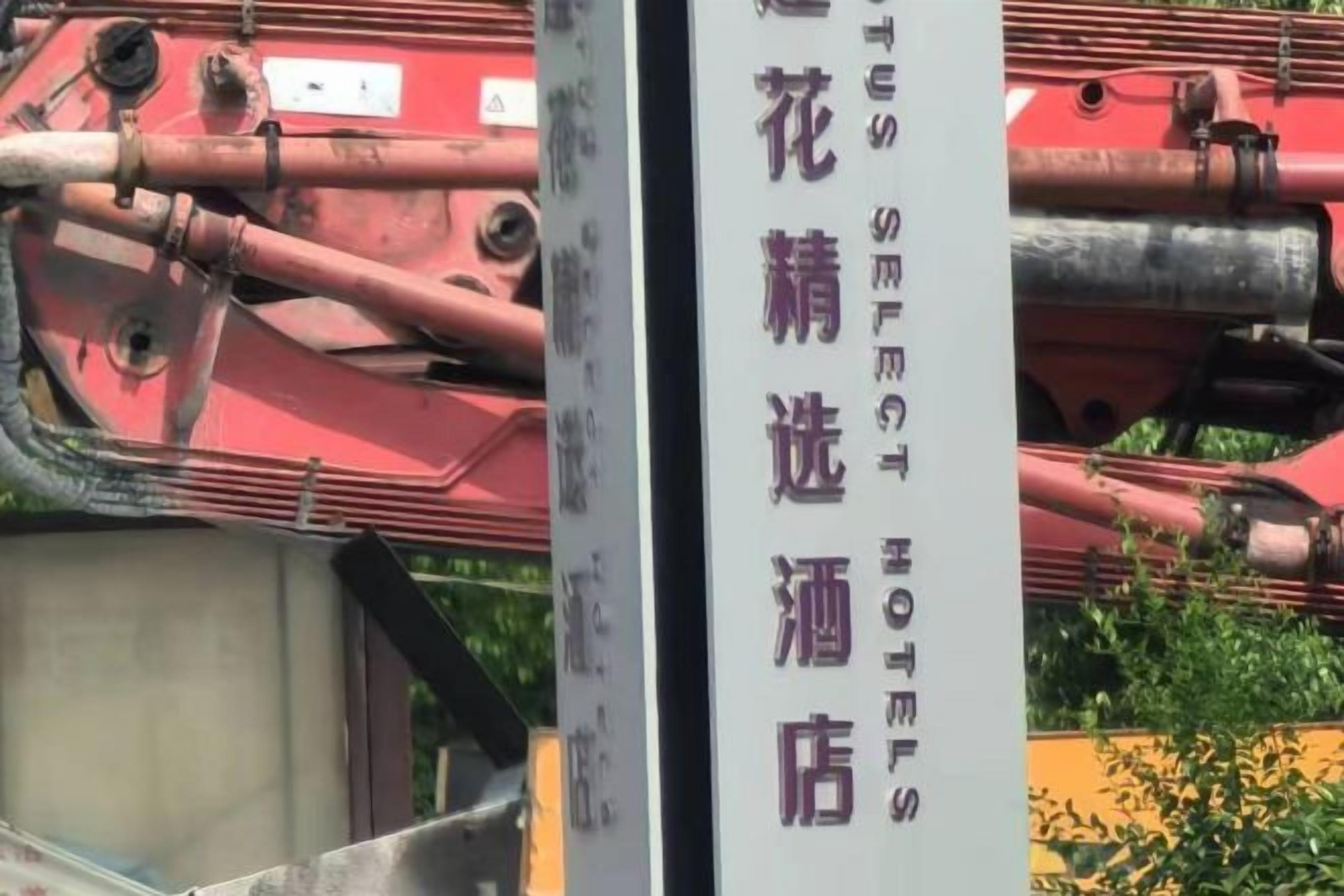 A vertical sign with text, partially obscured by a red mechanical structure.