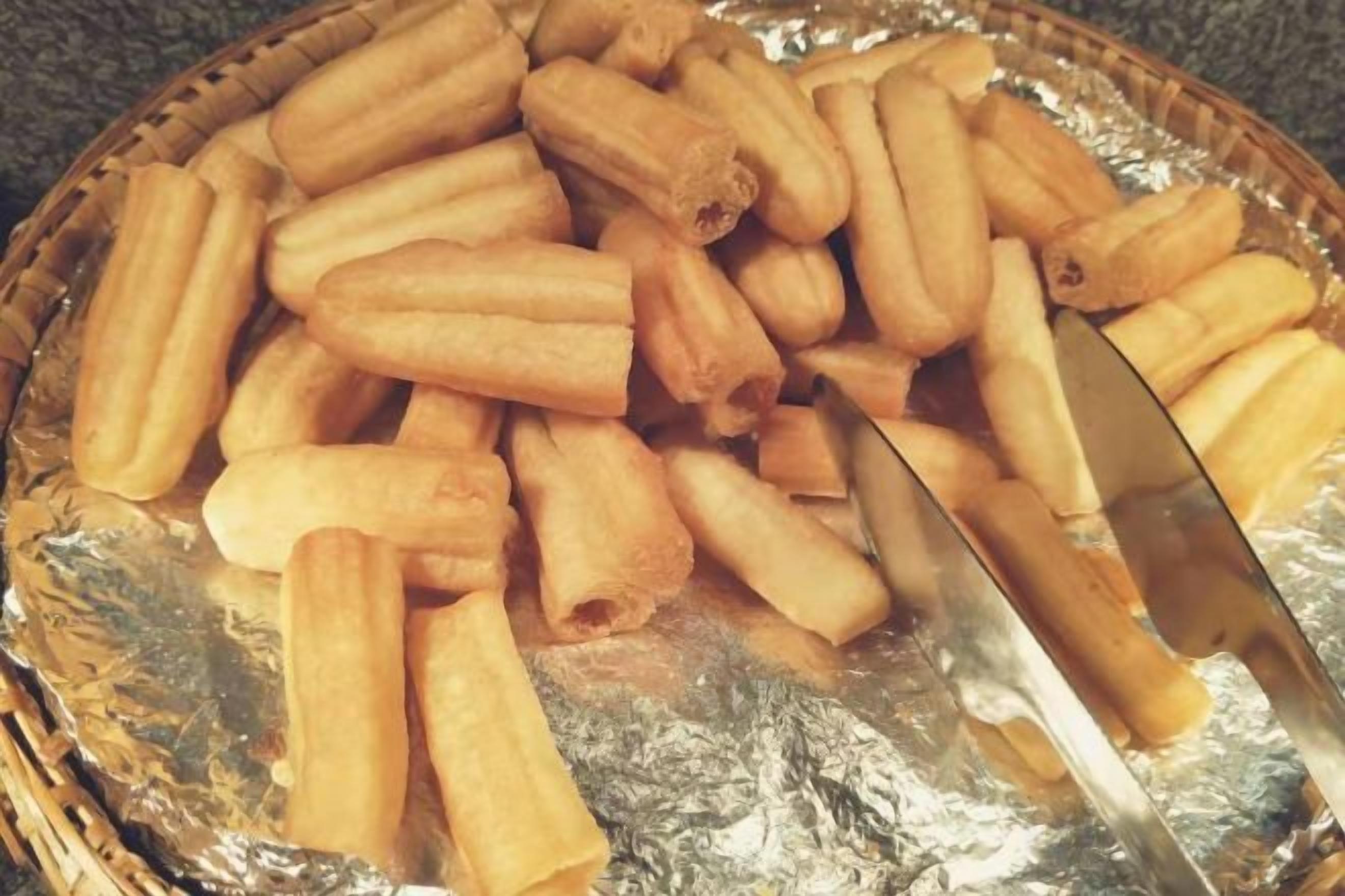 A basket filled with cylindrical pastries on a foil-lined surface.