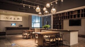 Ein modernes Interieur mit einem Holzbüro, einer Sitzecke und einem großen Fenster, das für natürliches Licht sorgt.