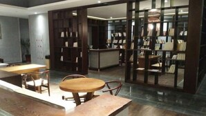 Eine moderne Bibliothek mit Holzbögen, einem Empfangstresen und Sitzbereichen.