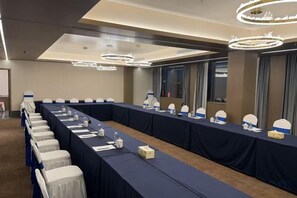 A conference room with a long table, chairs, and a row of nameplates.