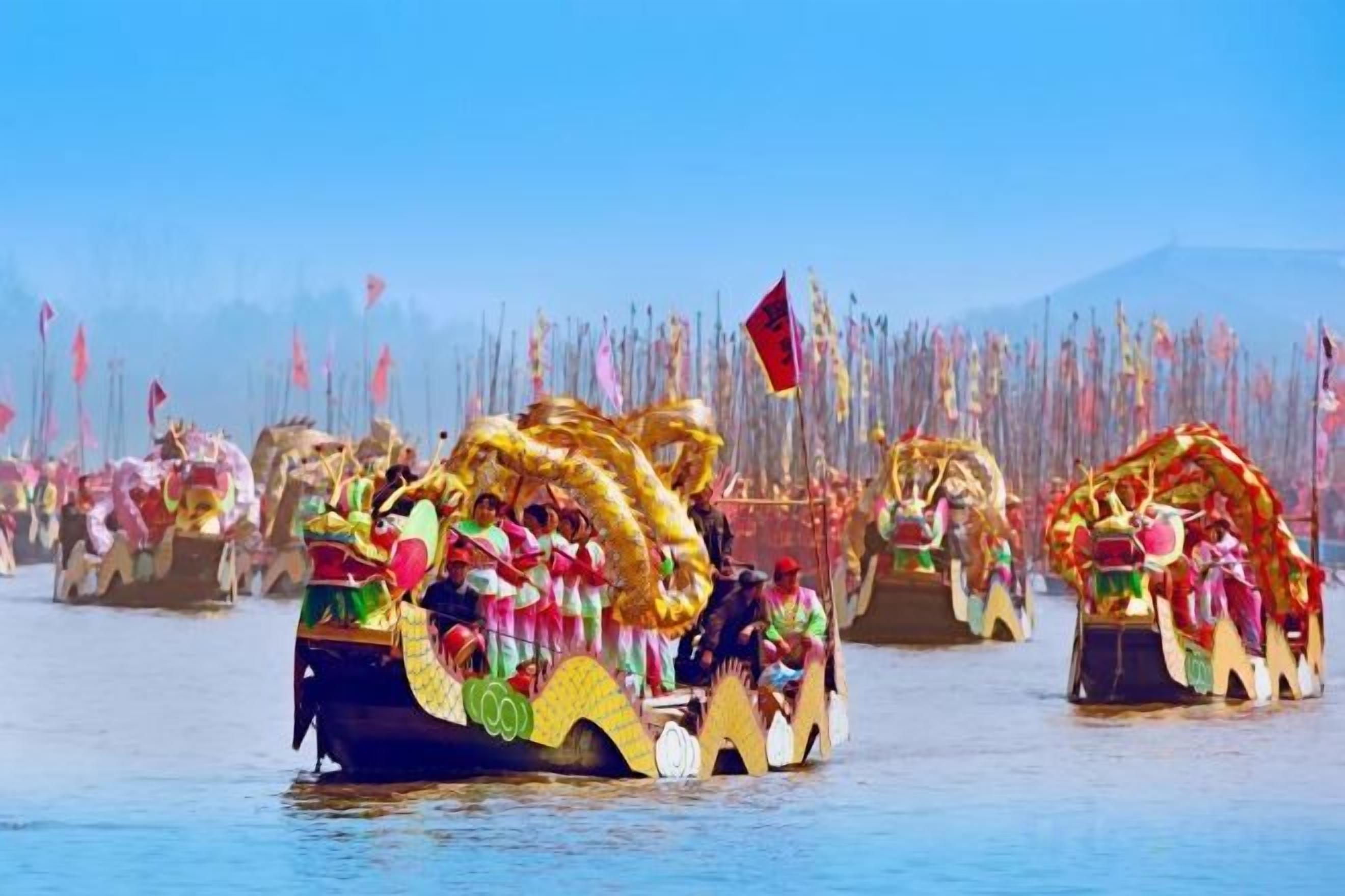 A group of ornate boats with intricate designs and flags, likely used for a cultural event or parade.
