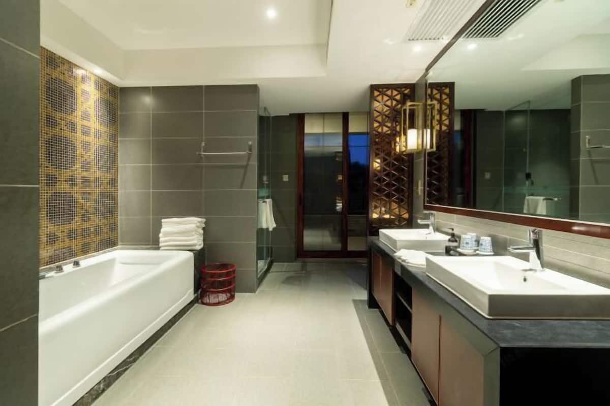 Un bagno moderno con una vasca da bagno ampia, due lavabi e un box doccia in vetro.