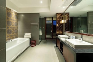 Un bagno moderno con una vasca da bagno ampia, due lavabi e un box doccia in vetro.