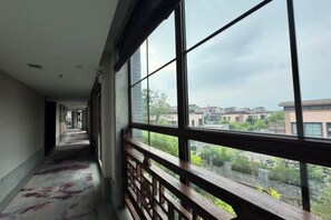 A corridor with large windows and a view of buildings outside.