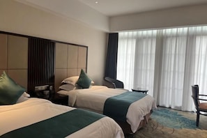 A hotel room with two beds, a large window with curtains, a small table, and a chair. - Laixian Island Hotel (Taizhou)