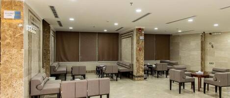 A spacious lobby with seating areas, a reception desk, and a marble floor.