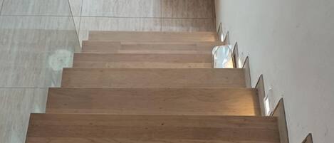 A wooden staircase with a handrail on the right side.