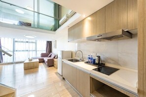 Une cuisine moderne dotée d’un grand îlot central, d’appareils électroménagers intégrés et d’un plafond en verre.