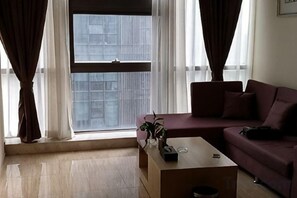 A living room with a sofa, a coffee table, and a window with curtains. - Fusion International Garden Apartment（Qingpu Branch Of Zhongshan Hospital） (Shanghai)