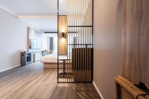 A modern hotel room with a wooden floor, a bed, a desk, and a large window. - HanTing Hotel (Dujiangyan) (Dujiangyan)