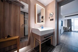 A modern bathroom with a wooden vanity, a large mirror, and a shower area. - HanTing Hotel (Dujiangyan) (Dujiangyan)