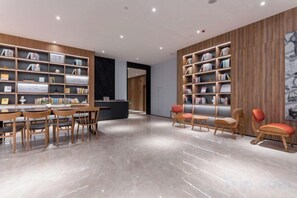 A modern library with wooden bookshelves, a reception desk, and seating areas. - HanTing Hotel (Dujiangyan) (Dujiangyan)