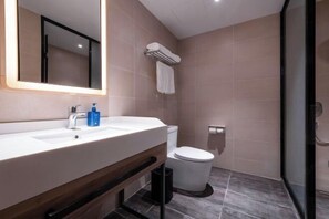 A modern bathroom with a white sink, mirror, and toilet. - HanTing Hotel (Dujiangyan) (Dujiangyan)