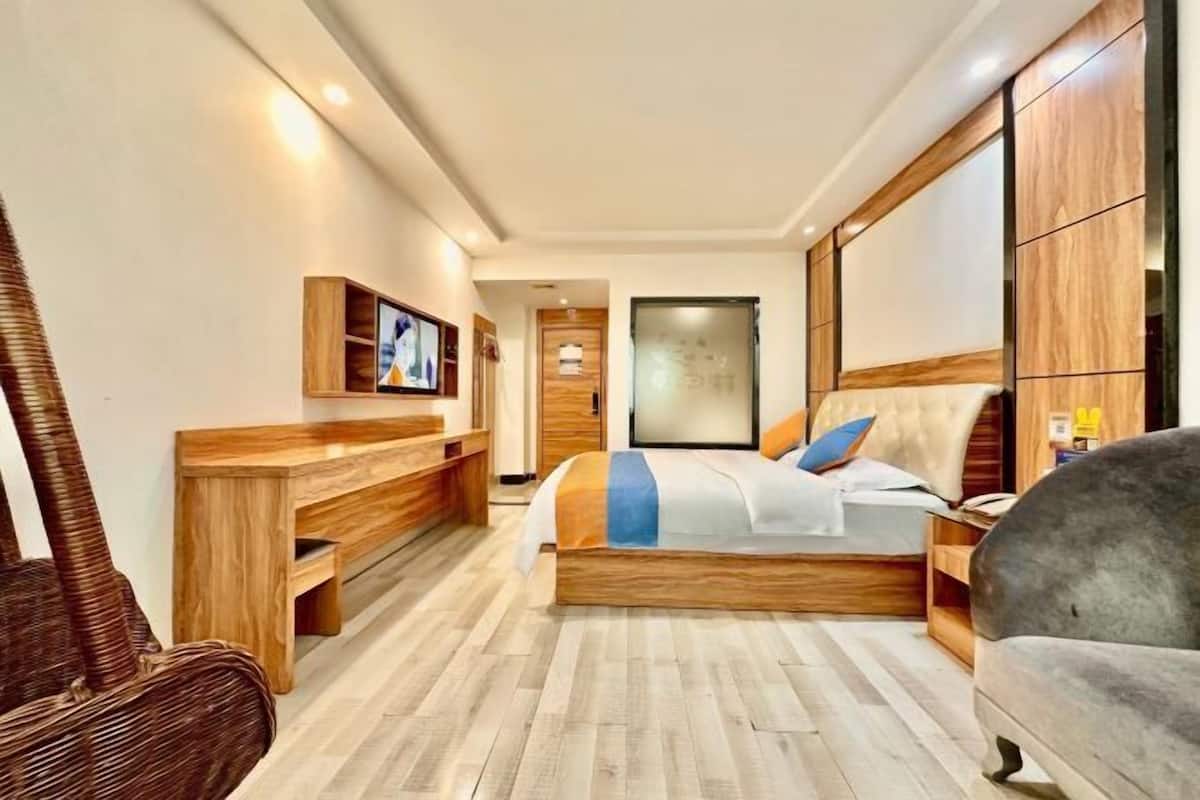 Un dormitorio moderno con una cama de madera, un sofá, un televisor y un escritorio.