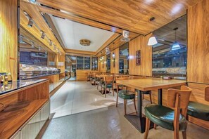 A restaurant interior with wooden paneling, a buffet counter, and seating arrangements. - Xingyue Hotel (Jiangnan Bus Terminal Dashatian Subway Station) (Nanning)