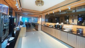 Eine moderne Hotelhalle mit einer langen Rezeption, Holzvertäfelung und einem Kronleuchter.