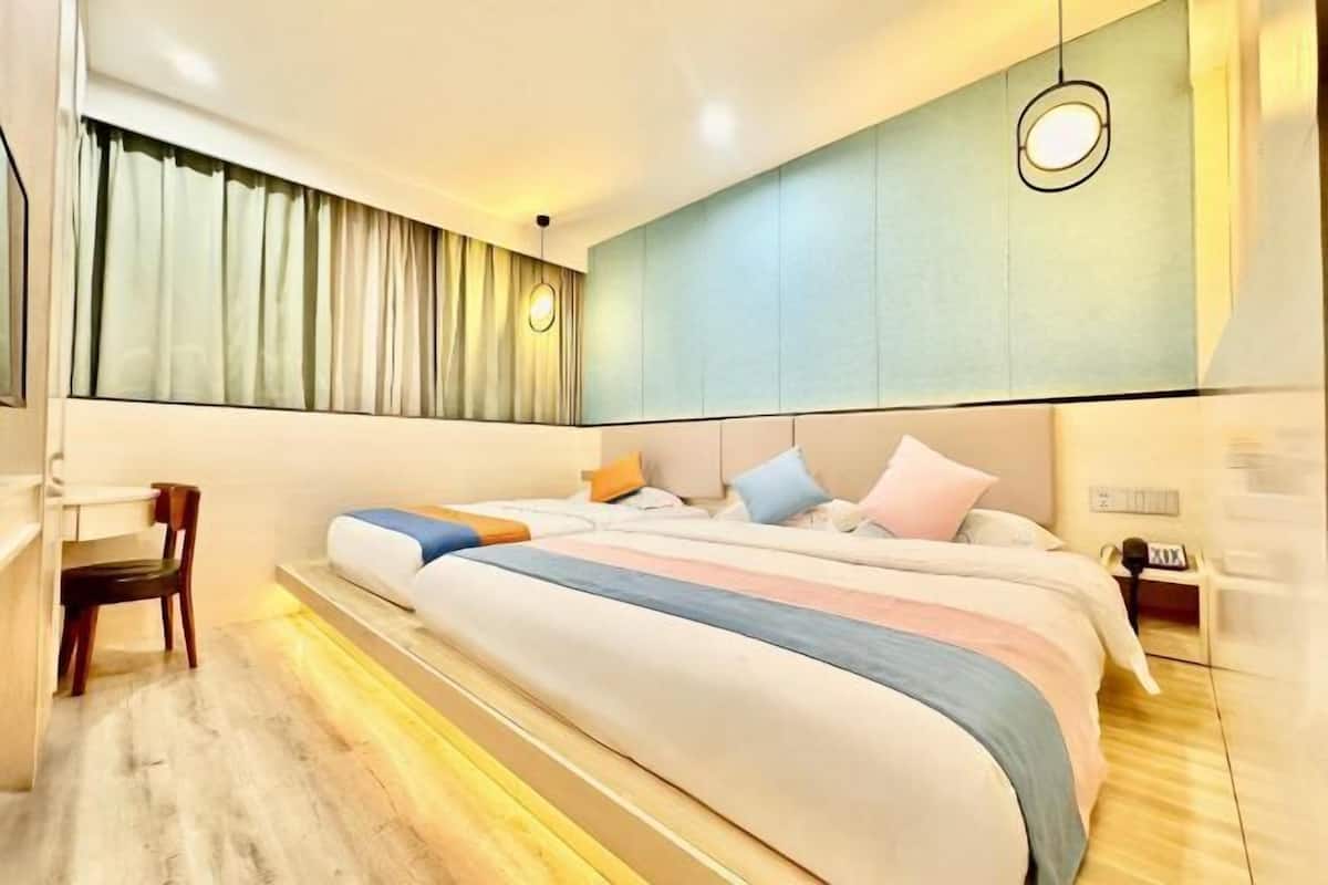 Un dormitorio moderno con una cama grande, un escritorio y una silla.