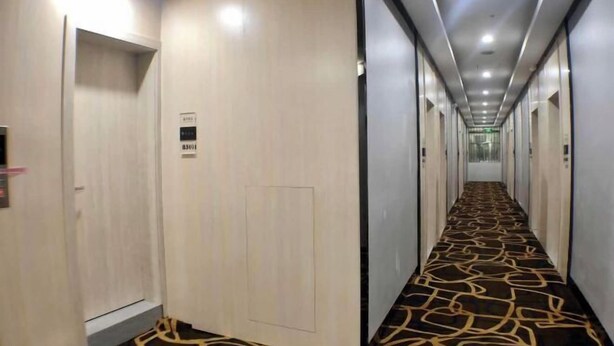 A hotel corridor with a patterned carpet, doors, and a long hallway. - Xingyue Hotel (Jiangnan Bus Terminal Dashatian Subway Station) (Nanning)