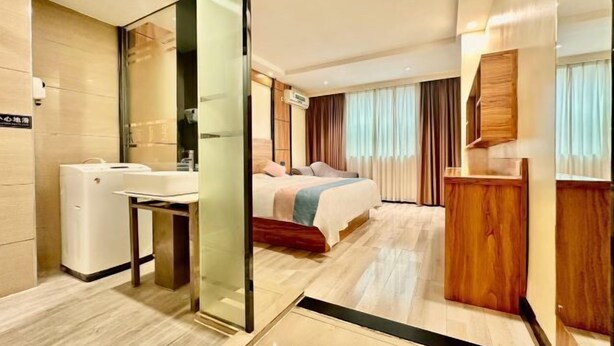 Ein Hotelzimmer mit Bett, Nachttisch und Spiegel.
