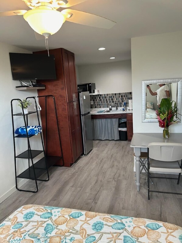 A compact living space with a kitchenette, a dining area, and a bedroom.