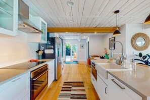 Enjoy cooking in this well-equipped kitchen with a central island, adjacent cabinetry, and large window offering a view of the outdoors.
