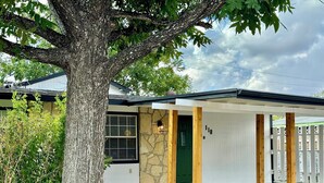 Una casa con fachada de piedra, una puerta verde y un cartel con el número 118.