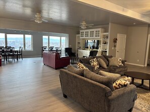 A spacious living room with a large window, a fireplace, and a dining area with a view. - Springville Welcome Home: spacious 5-bedroom house in delightful Springville (Springville)