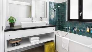 A modern bathroom with a white sink, a mirror, a shower with a glass door, and a yellow trash bin. - The 1880 Boutique Holiday Home in The Heart of Antwerp (Antwerpen)