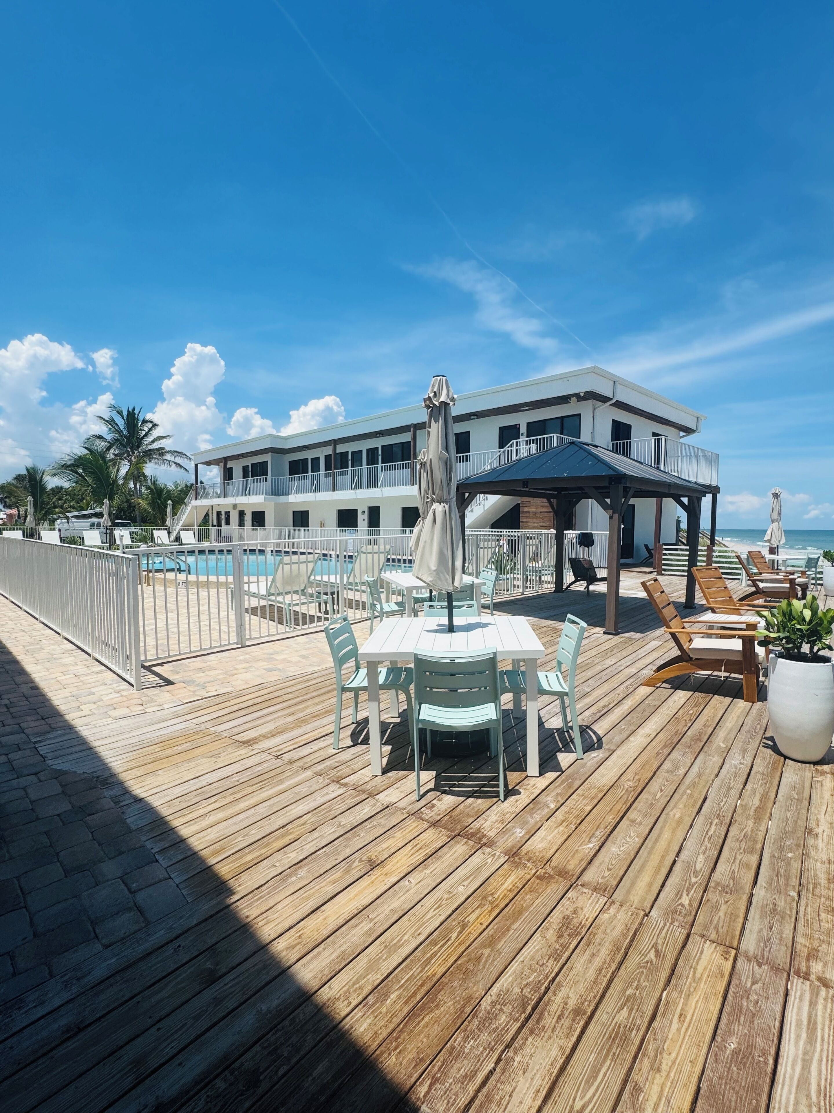 Una terraza de madera con mobiliario exterior y zona de piscina.