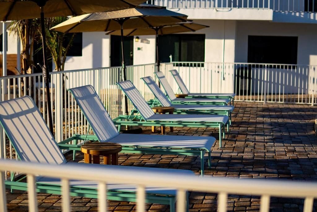 A poolside area with sun loungers and umbrellas.