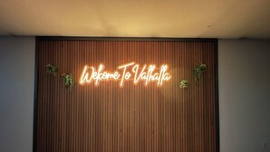 A neon sign on a wooden wall that reads "Welcome to Valhalla." - Huge Breathtaking Cabin on Shetek/Swim-Grill-Games (Slayton)