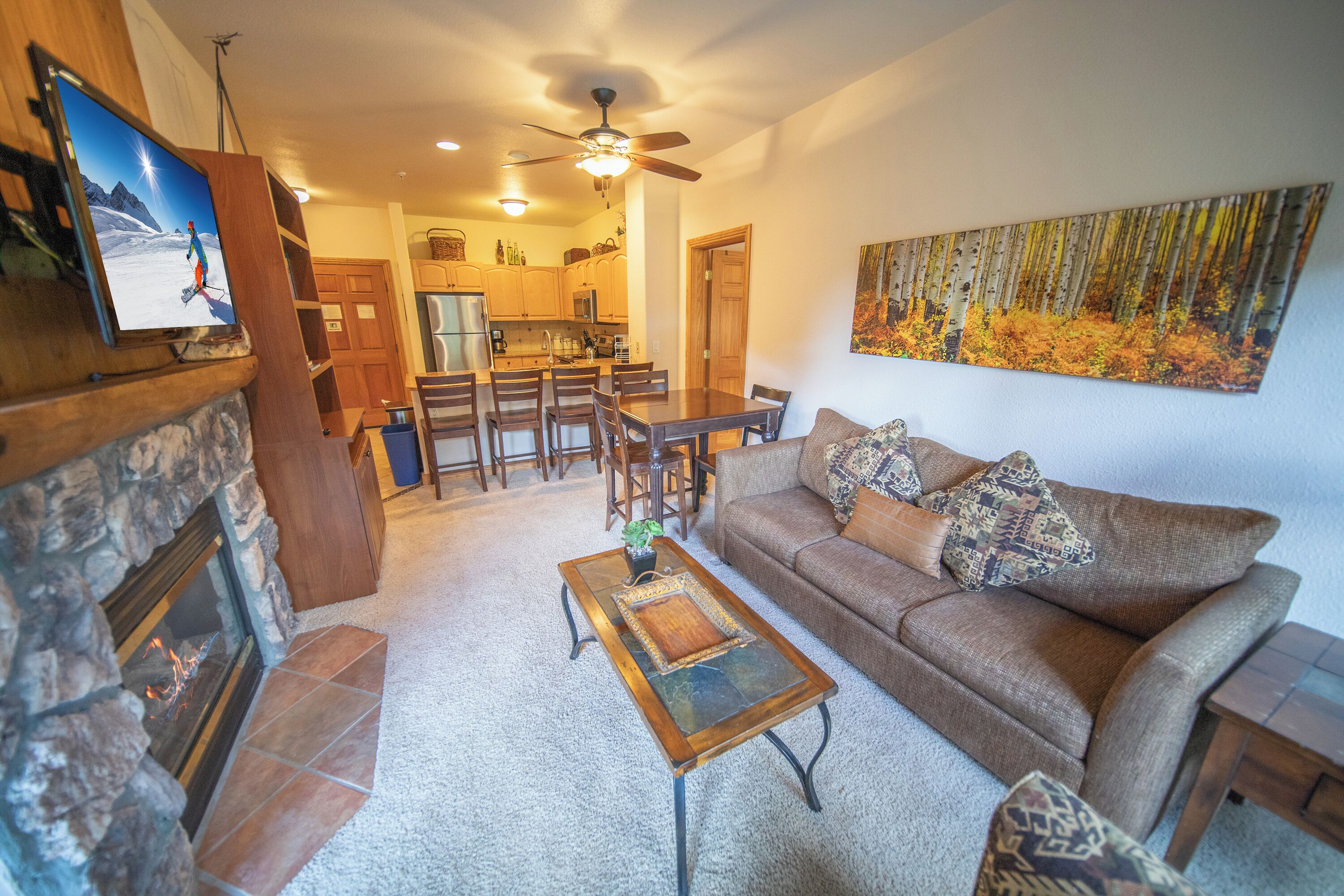 A living room with a fireplace, a sofa, a coffee table, and a television.