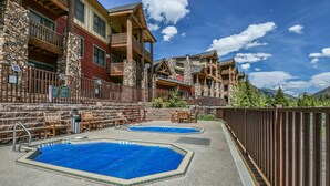 A resort with two outdoor swimming pools, wooden deck chairs, and a stone wall. - Hidden River Lodge 5969 (Keystone)