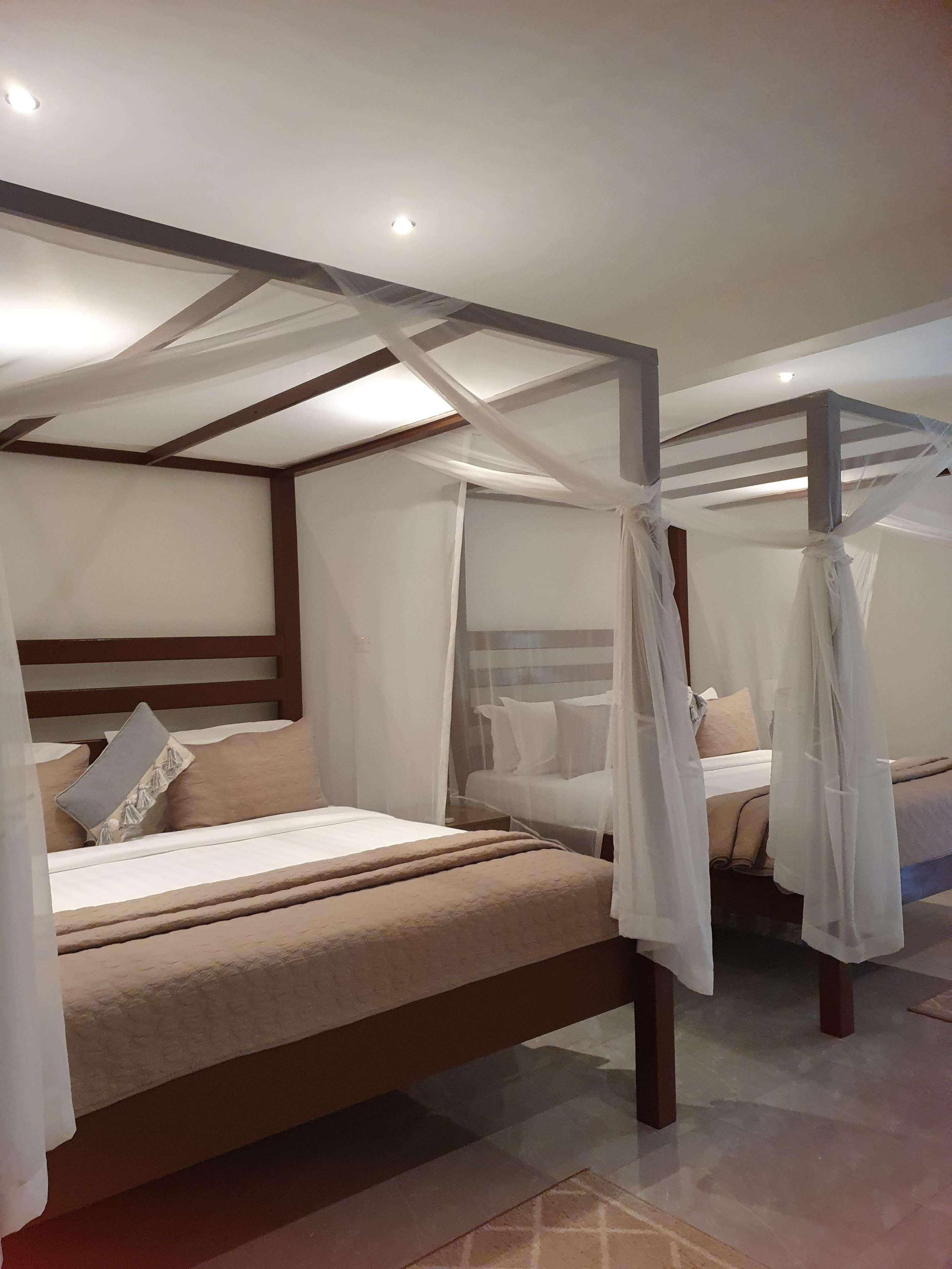 Una camera da letto con un letto a baldacchino, un letto singolo e un comodino.
