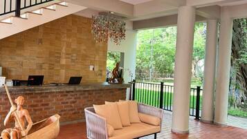 A spacious indoor area with a wooden bench, a cushioned sofa, and a stone wall.