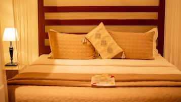 Un letto rifatto con una coperta marrone e due cuscini decorativi.
