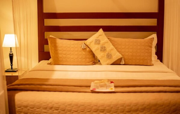 A neatly made bed with a brown blanket and two decorative pillows. - Waters Edge By Serendib (Liwonde)