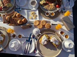 A breakfast buffet with various dishes, including eggs, toast, and pastries, arranged on a table. - Waters Edge By Serendib (Liwonde)