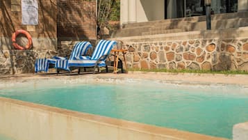A pool area with lounge chairs and a lifebuoy.