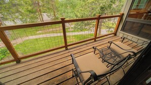 A wooden deck with a metal railing and two chairs. - Flying Dutchman 1126 (Keystone)