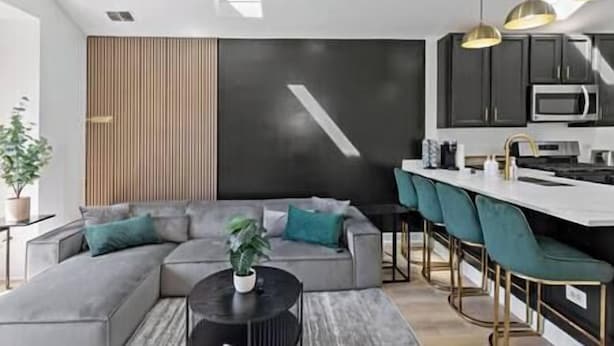 Una sala moderna con un sofá modular, una mesita de centro y una planta en maceta.