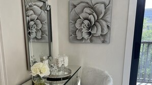 A modern vanity with a glass top, a fluffy chair, and a large floral artwork on the wall. -  Marco Island Townhouse walking distance to South End Beach (Marco Island)