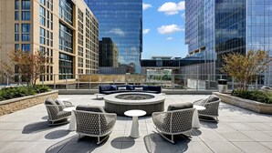 Una terrazza sul tetto con posti a sedere all'aperto, un braciere e vista sui palazzi circostanti.