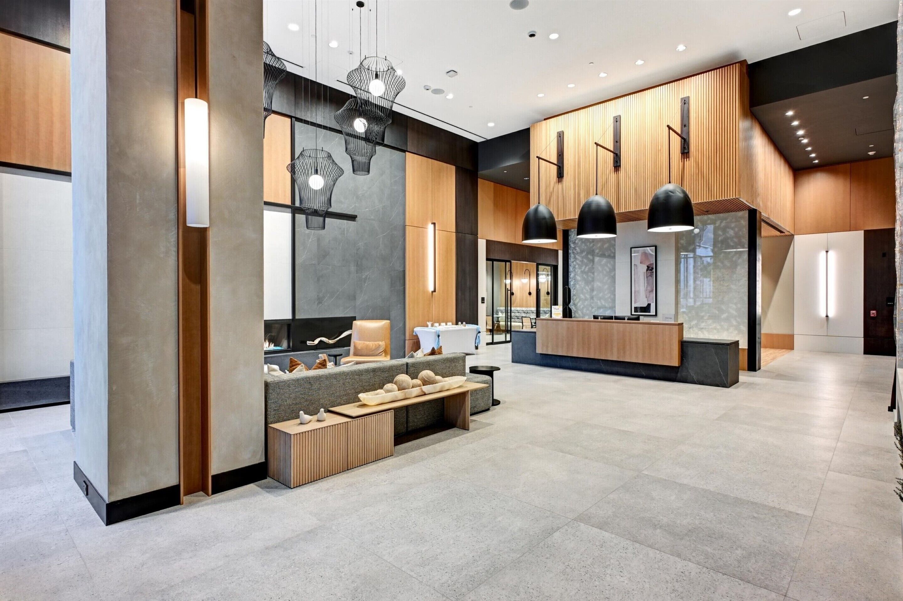 Un vestíbulo moderno con mostrador de recepción, zona de estar e iluminación contemporánea.