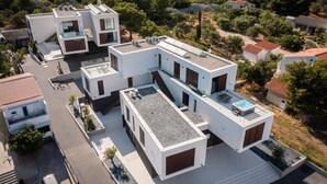 A modern multi-story residential building with a rooftop terrace, solar panels, and a swimming pool. - Luxurious apartment in Betina with WiFi (Betina)