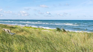 A grassy beach area with a bench and a view of the ocean. - 5 bedroom awesome home in Slagelse (Slagelse)